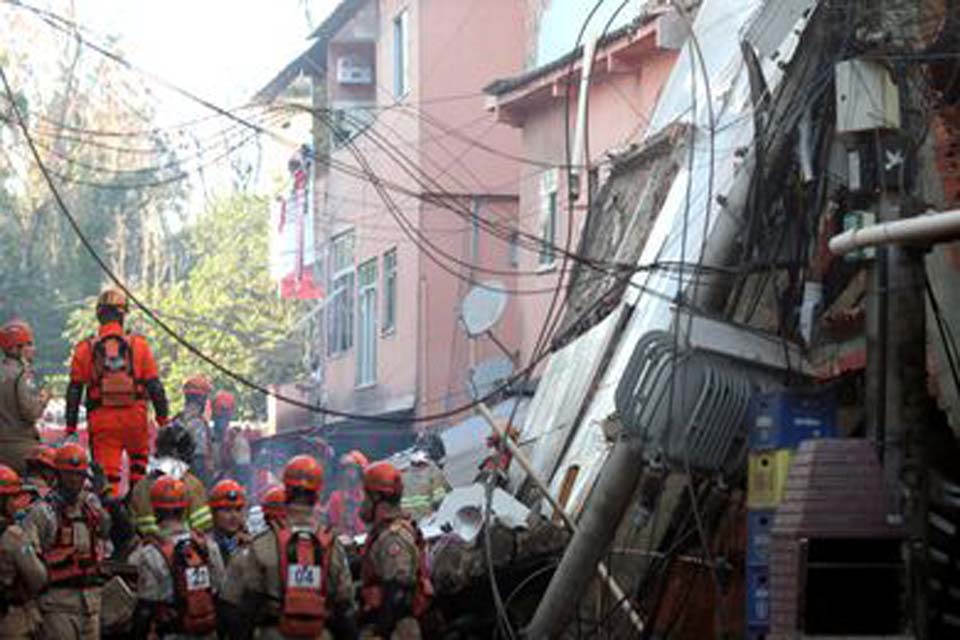 Bombeiros resgatam mulher sob escombros de prédio que desabou na na comunidade de Rio das Pedras